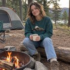Woman wearing the Cabin Smoke Sweatshirt in Blue Spruce at a campsite