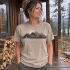 Woman wearing the Cabin Smoke T-Shirt in Sandstone on a cabin porch