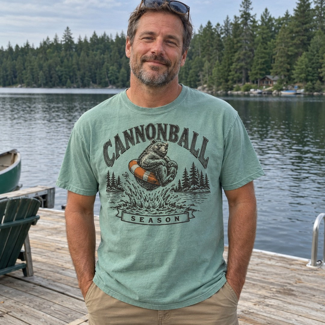 Man wearing the Cannonball Season bear T-shirt on a lake dock