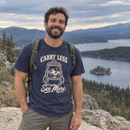 Man wearing the Carry Less, See More T-Shirt at a lake overlook