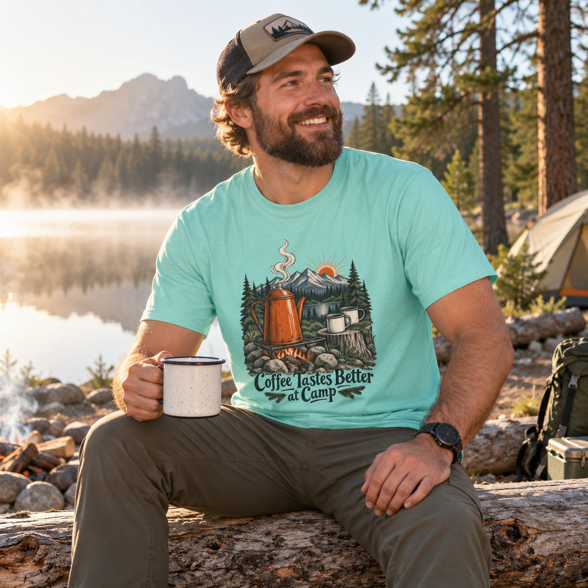 Man wearing the Coffee Tastes Better at Camp T-shirt at a lakeside campsite