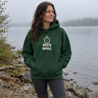 Woman wearing the North of Normal hoodie on a misty lakeshore in the morning