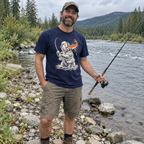 Man fishing by a river wearing the Gone Fishing Grizzly T-Shirt