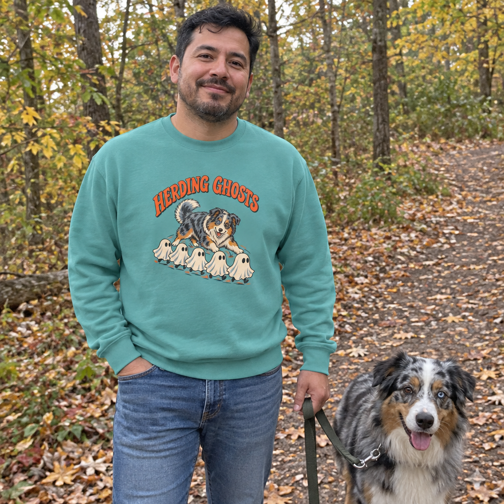 Man wearing the seafoam Herding Ghosts sweatshirt on a fall trail with his Australian Shepherd