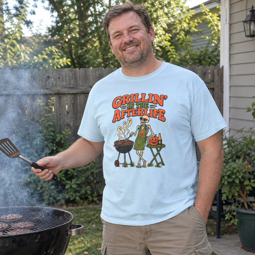 Man wearing the light blue Grillin' in the Afterlife t-shirt at his backyard grill