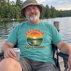 Man wearing the seafoam Fresh Air & Low Expectations t-shirt in a camp chair on a lake dock