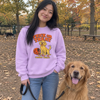 Woman wearing the orchid Trick or Treat (Mostly Treat) sweatshirt at the dog park with her golden retriever