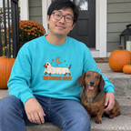 Man wearing the lagoon blue The Longest Ghost sweatshirt on porch steps with his dachshund
