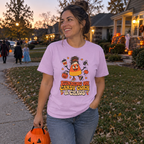 Woman wearing the orchid Running on Candy Corn and Chaos t-shirt trick-or-treating at dusk
