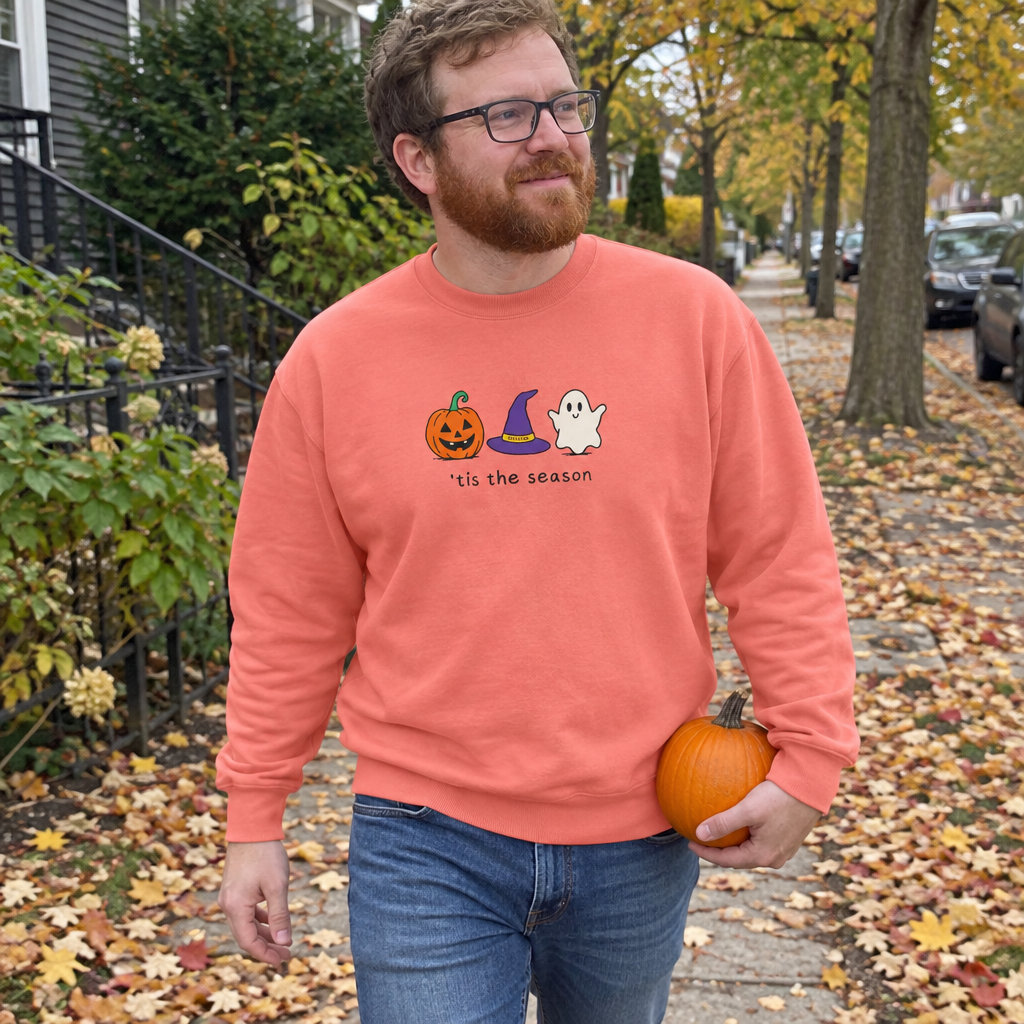 Man wearing the salmon Tis the Season sweatshirt on a fall leaf-covered sidewalk