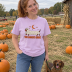 Woman wearing the orchid The Longest Ghost t-shirt at a pumpkin patch with her dachshund