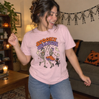 Woman wearing the pink Spooky Season Dancing Skeletons t-shirt dancing in her Halloween living room
