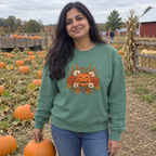 Woman wearing the Light Green Harvest Grin sweatshirt in a pumpkin patch