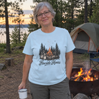 Woman wearing the light blue Fireside Hours t-shirt at a campsite by the fire