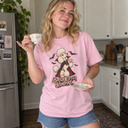Woman wearing the Blossom pink Bougie Little Vampire t-shirt sipping tea in her kitchen