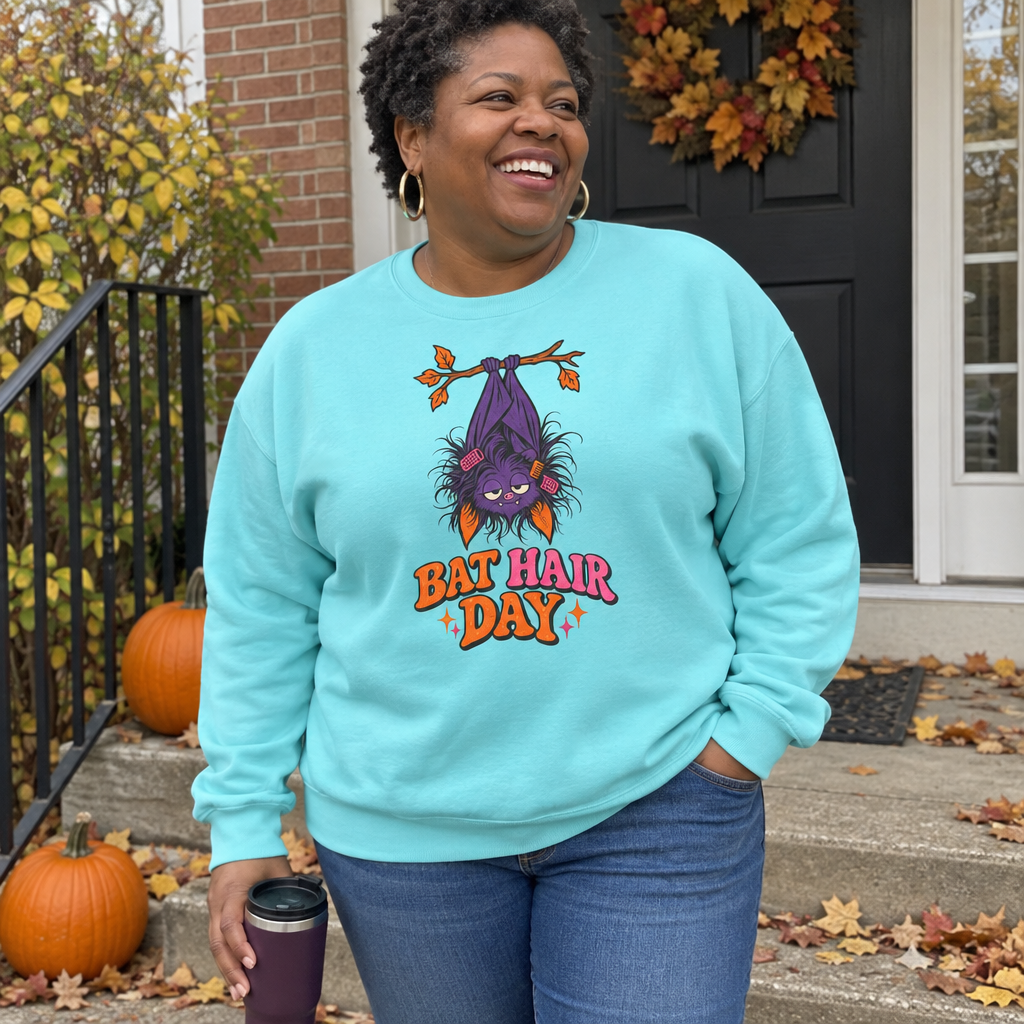 Woman wearing the aqua Bat Hair Day sweatshirt on her front steps with pumpkins