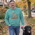 Man wearing the seafoam Bonded for Life sweatshirt walking his black Lab on a fall sidewalk