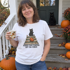 Woman wearing the white Pushed Your Pumpkin Off the Porch t-shirt on fall porch steps with a black cat