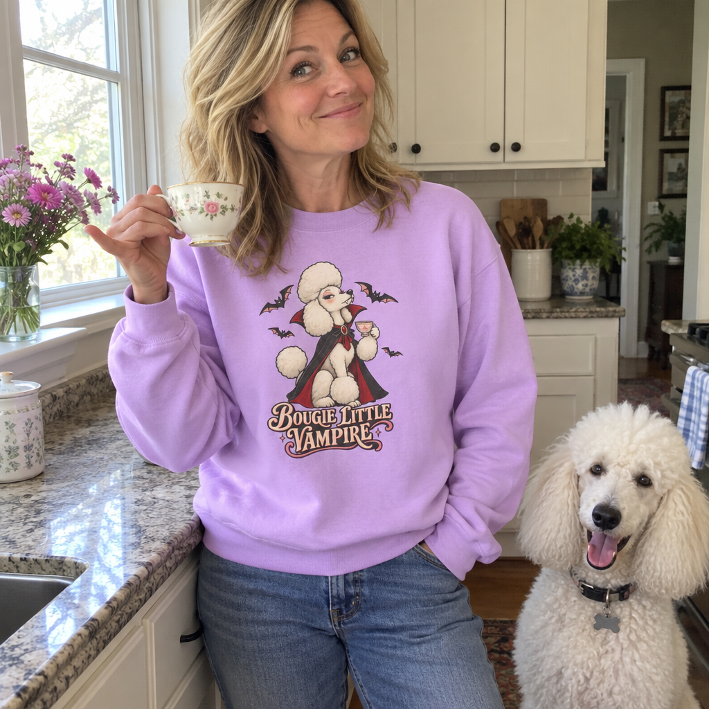 Woman wearing the lilac Bougie Little Vampire sweatshirt sipping tea in her kitchen