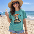 Woman wearing the seafoam SPF 1000 t-shirt on the beach with sunscreen