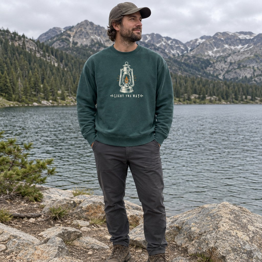Man wearing the Light the Way crewneck sweatshirt by a mountain lake