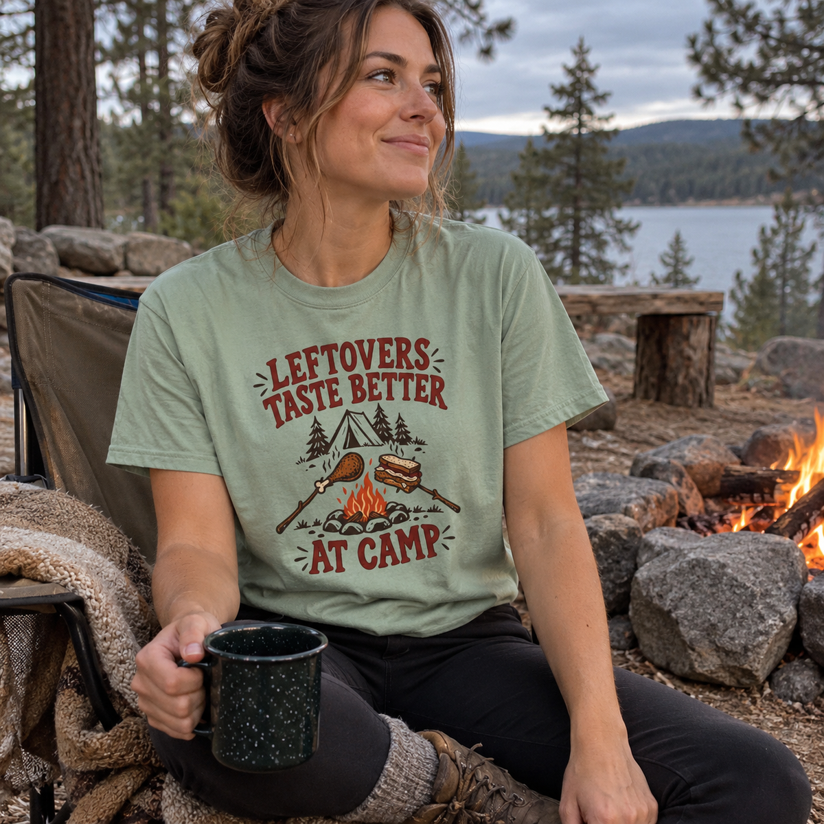 Woman wearing the Leftovers Taste Better at Camp T-Shirt by a campfire
