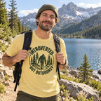Man wearing the Introverted but Outdoorsy Bigfoot t-shirt by a mountain lake