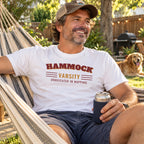Man wearing the Hammock Varsity t-shirt in a backyard hammock