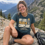 Woman wearing the My Legs Filed a Complaint T-Shirt resting on a rock on a mountain trail