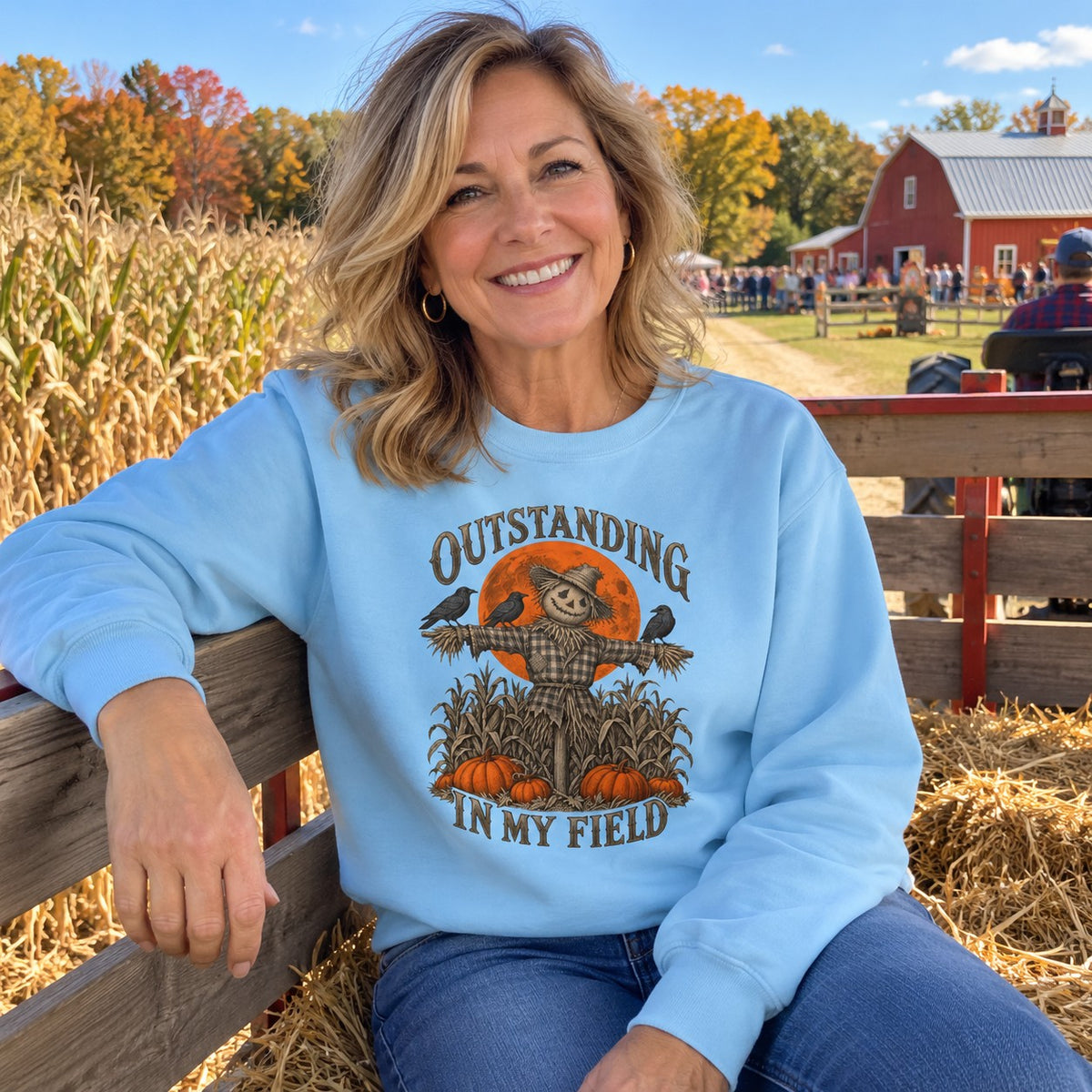 Woman on a hayride wearing the Outstanding in My Field Sweatshirt