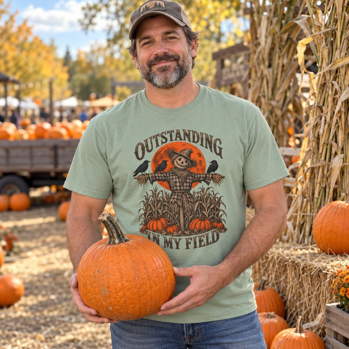 Man at a pumpkin patch wearing the Outstanding in My Field T-Shirt