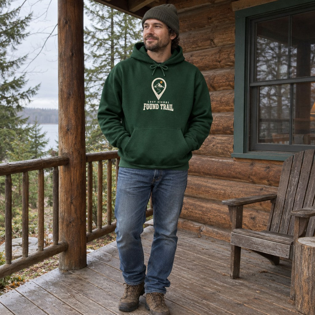 Man wearing the Lost Signal, Found Trail hoodie at a cabin porch
