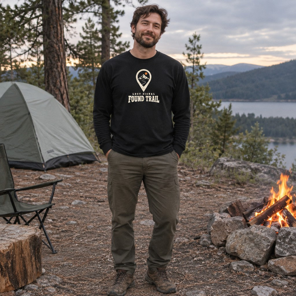 Man wearing the Lost Signal, Found Trail long sleeve shirt at a campsite in the evening