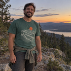 Man wearing the Pine Ridge Moon T-Shirt on a pine ridge