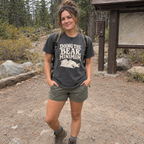Woman wearing the Doing the Bear Minimum T-Shirt in a pine forest