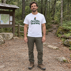 Man wearing the Out of Office, Into the Woods T-Shirt at a trailhead