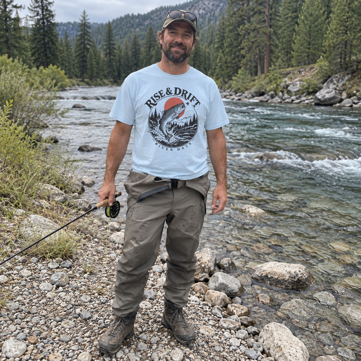 Man wearing the Rise & Drift T-shirt by a river