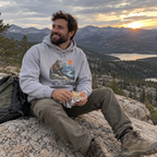 Man wearing the sport grey Hiked Two Miles for This Sandwich hoodie on a mountain overlook