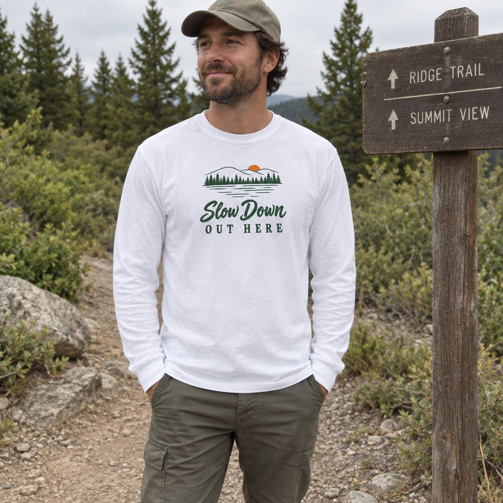 Man wearing the Slow Down Out Here long sleeve shirt at a trail sign