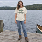 Woman wearing the Slow Down Out Here T-shirt standing on a wooden lake dock