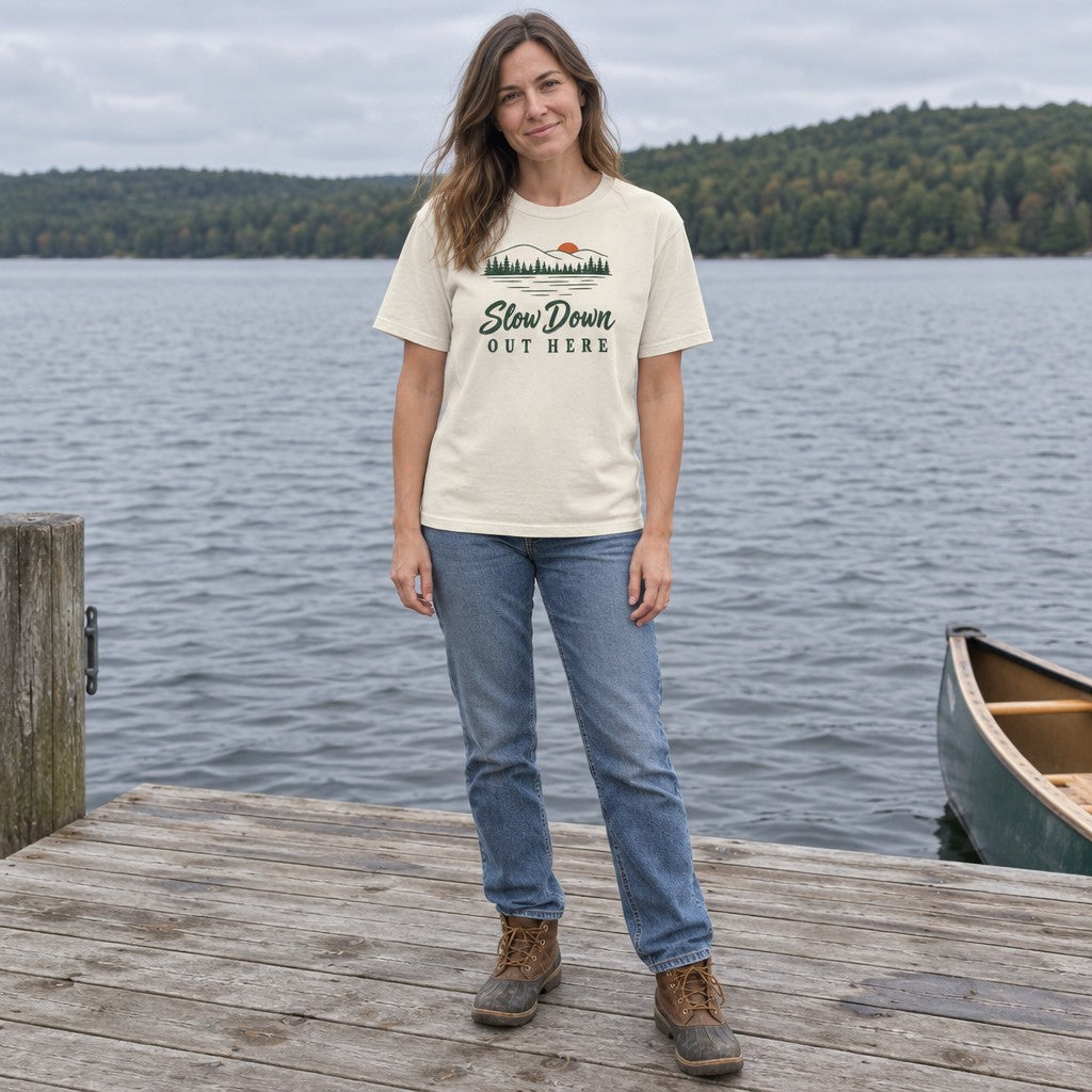 Woman wearing the Slow Down Out Here T-shirt standing on a wooden lake dock