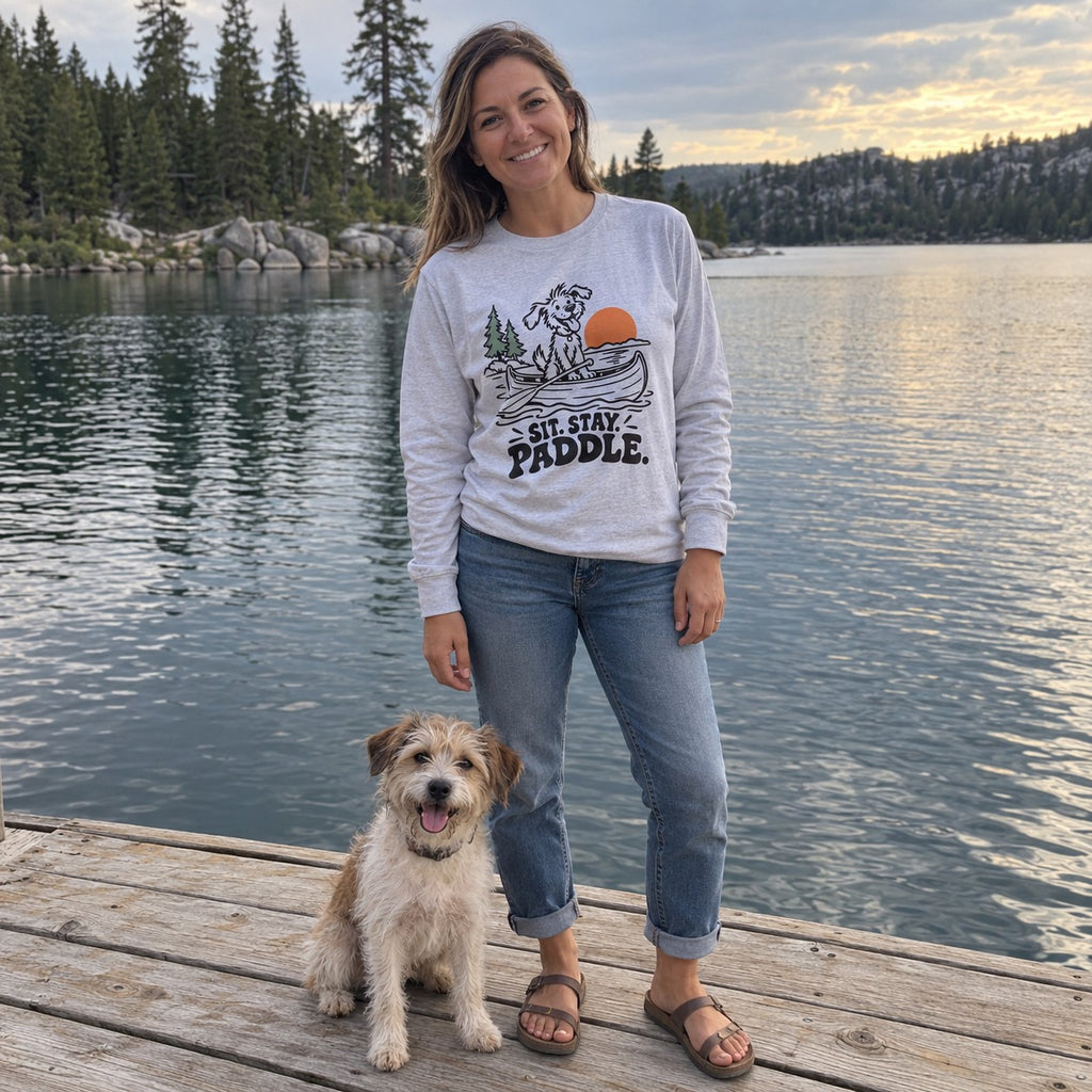 Woman on a lake dock wearing the Sit. Stay. Paddle. Long Sleeve Shirt with her dog