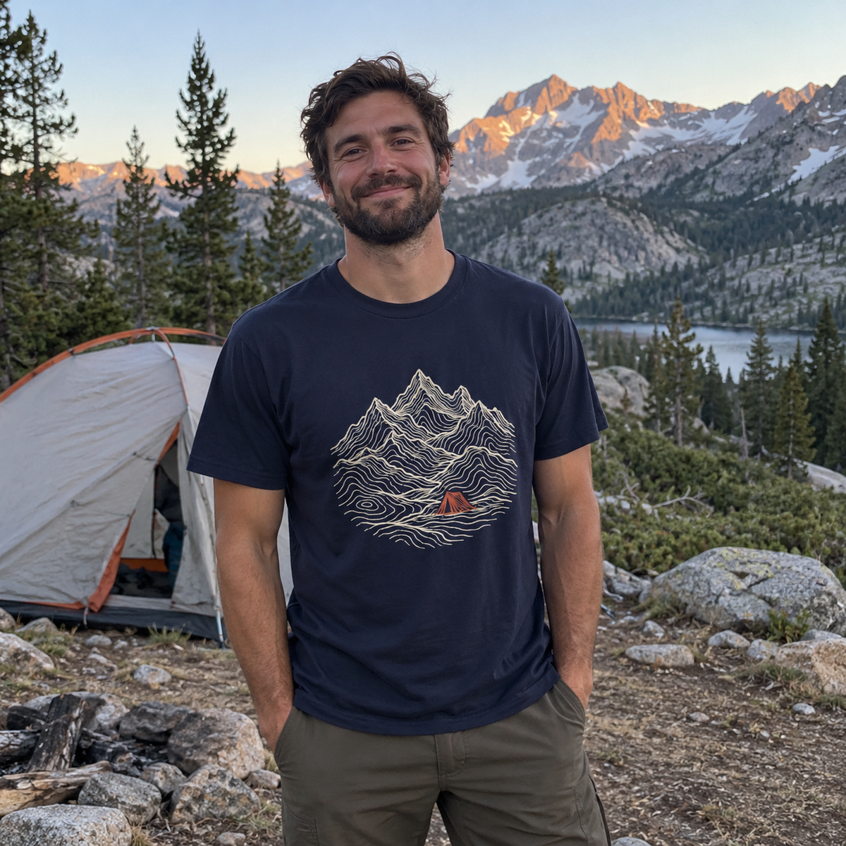 Man wearing the Tent Under the Peaks T-Shirt at a mountain campsite