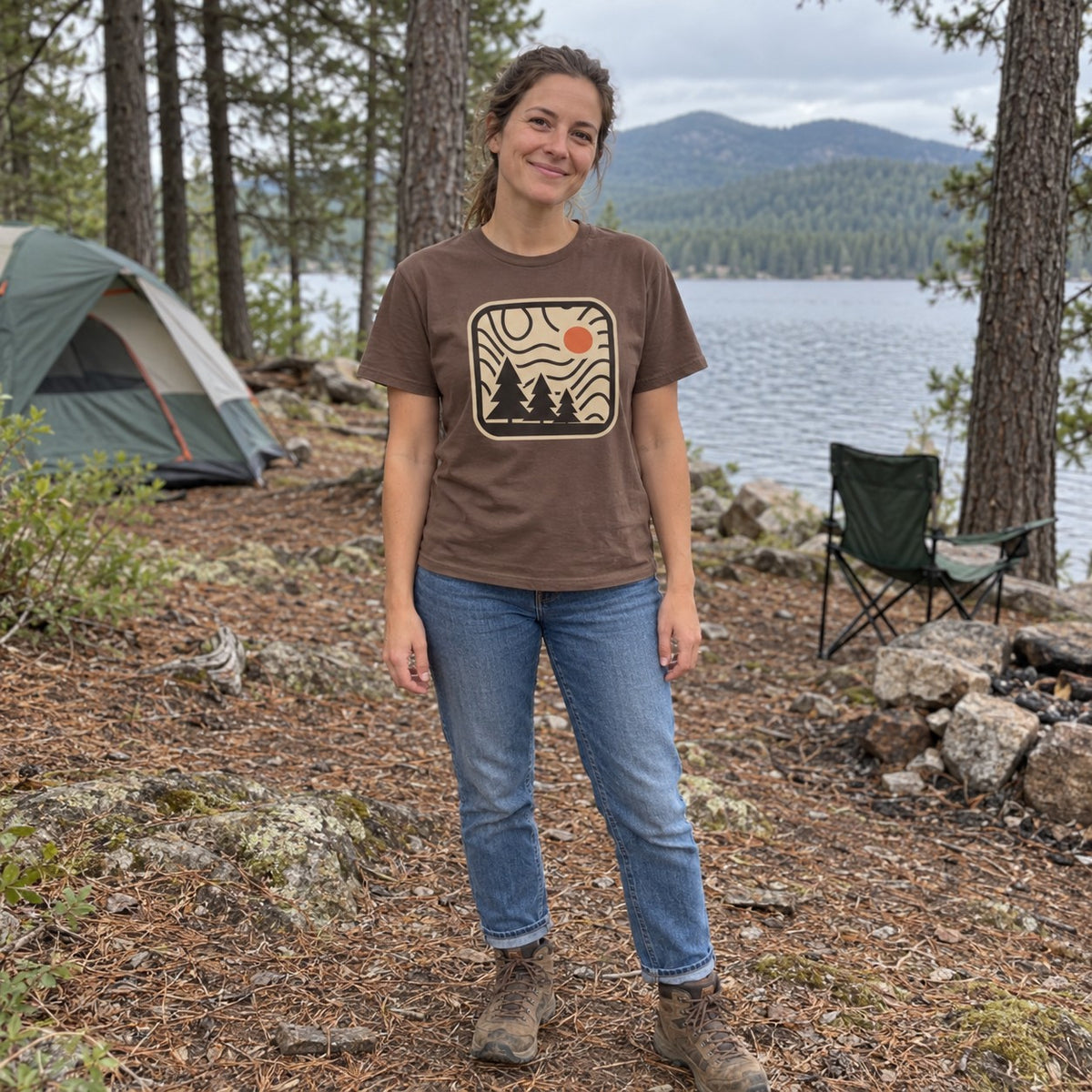Woman wearing the Topo Pines T-Shirt at a lakeside campsite