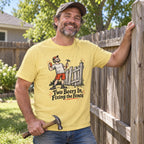Man wearing the Two Beers In, Fixing the Fence T-Shirt by a fence