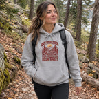 Woman wearing the Out of Breath Hiking Society Log Steps Hoodie on a forest trail with a backpack