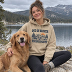 Woman wearing the Out of Breath Hiking Society Flat Out Hoodie by a lake with a golden retriever