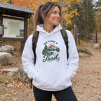 Woman wearing the Go Find a Trail Hoodie at a fall trailhead with a backpack