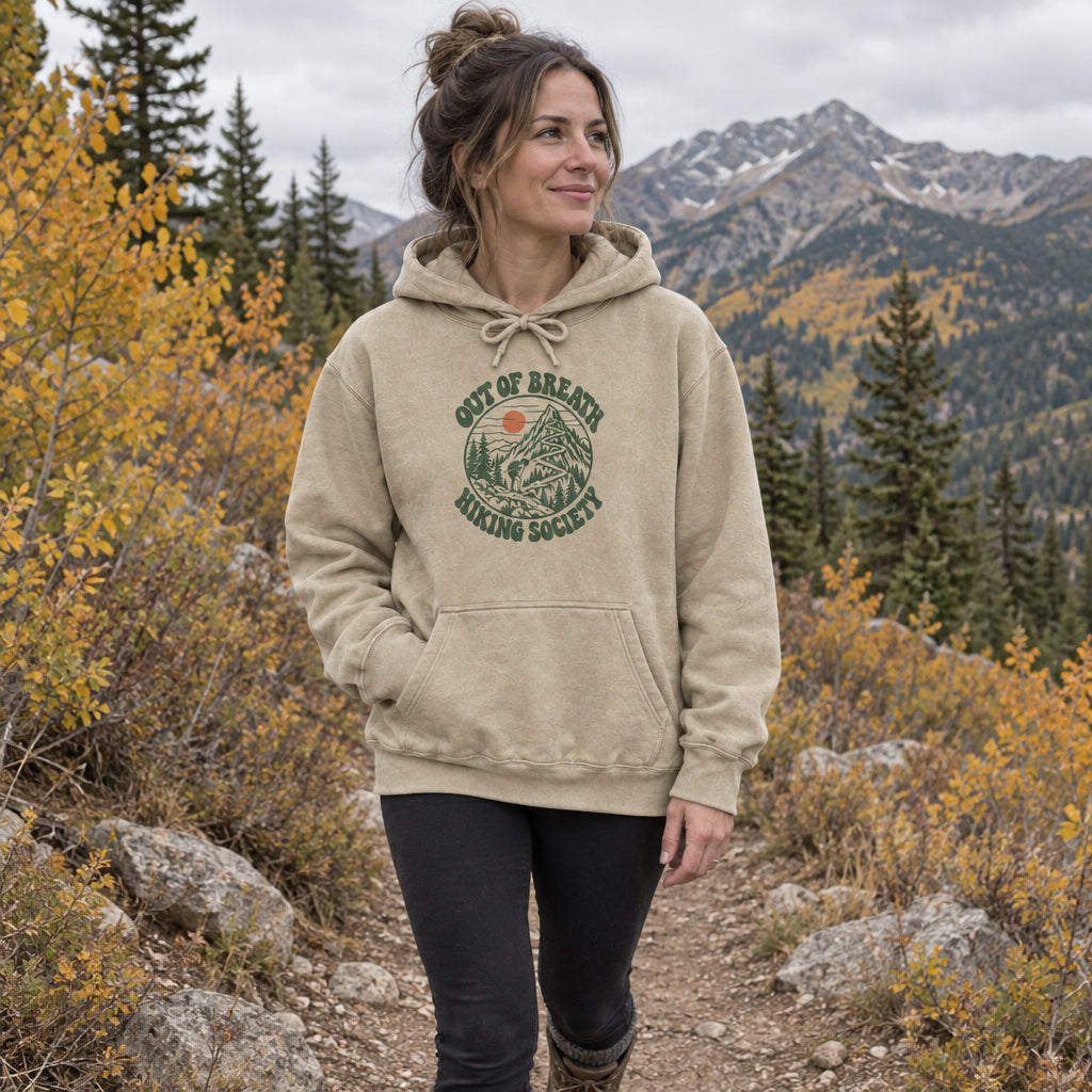 Woman wearing the Out of Breath Hiking Society Switchback Hoodie on a fall mountain trail
