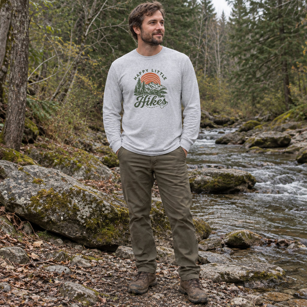Man wearing the Happy Little Hikes Long Sleeve Shirt by a forest creek